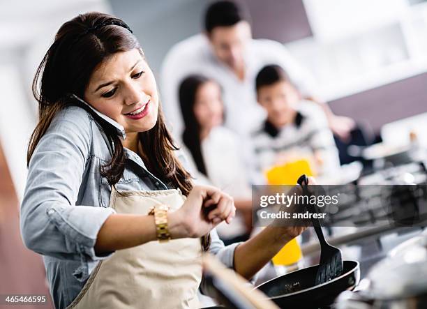 busy mum cooking at home - busy woman stockfoto's en -beelden