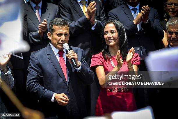 Peru's President Ollanta Humala delivers a speech to the crowd gathered outside the presidential palace in Lima, as his wife Nadine Heredia applauds,...