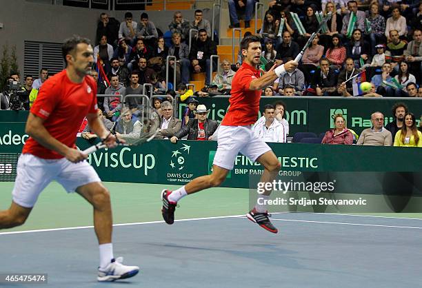 Novak Djokovic and Nenad Zimonjic of Serbia in action against Marin Draganja and Franko Skugor of Croatia during their men's double match on the day...