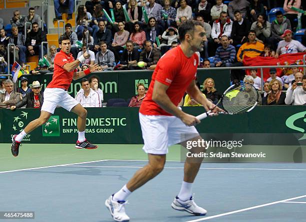 Novak Djokovic and Nenad Zimonjic of Serbia in action against Marin Draganja and Franko Skugor of Croatia during their men's double match on the day...