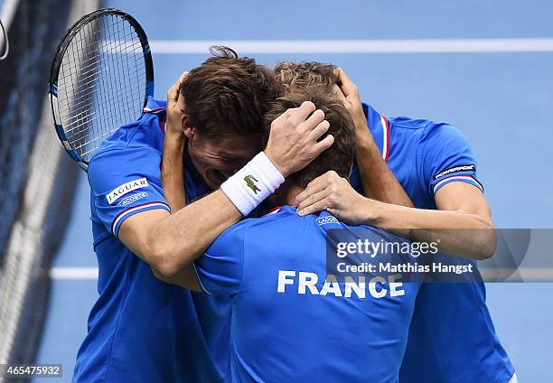 Team captain Arnaud Clement of France celebrates with Julien Benneteau and Nicolas Mahut of France after winning their match against Benjamin Becker...