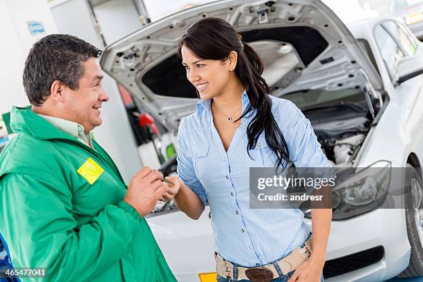 frau geben autoschlüssel zu mechaniker - happy client by broken car stock-fotos und bilder