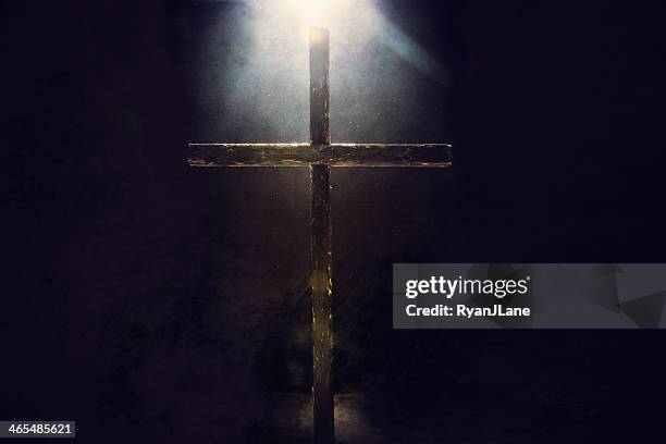 dunkle cross mit licht über dem kopf - cross religion stock-fotos und bilder