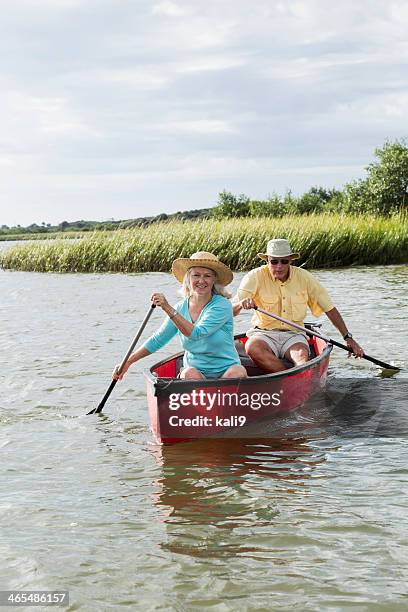 senior couple canoeing together on intracoastal waterway - seniors canoeing stock pictures, royalty-free photos & images