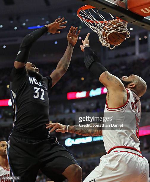Ronny Turiaf of the Minnesota Timberwolves dunks over Carlos Boozer of the Chicago Bulls at the United Center on January 27, 2014 in Chicago,...