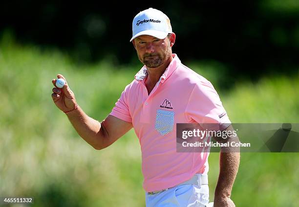 Alex Cejka of Germany holds up his ball after putting for birdie on the seventh green during round three of the Puerto Rico Open presented by Banco...