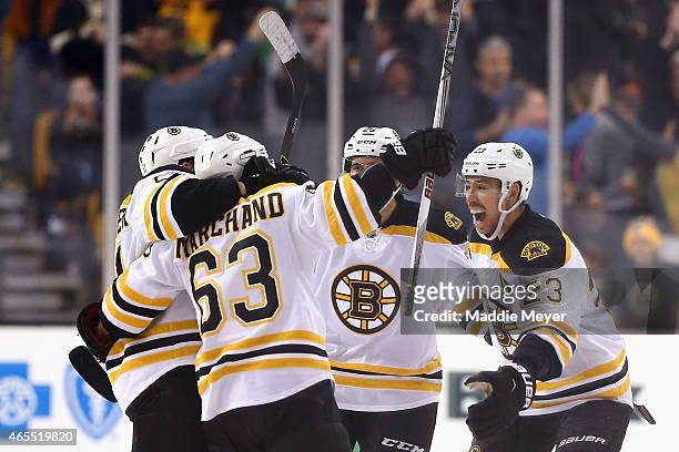 Ryan Spooner, Chris Kelly and Maxime Talbot congratulate Brad Marchand of the Boston Bruins after he scored the game winning goal in overtime against...