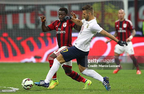 Panagiotis Tachtsidis of Hellas Verona FC competes for the ball with Sulley Ali Muntari of AC Milan during the Serie A match between AC Milan and...