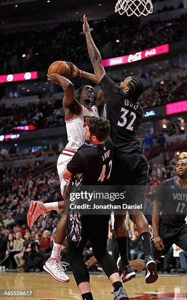 Tony Snell of the Chicago Bulls charges into Kevin Love and Ronny Turiaf of the Minnesota Timberwolves at the United Center on January 27, 2014 in...