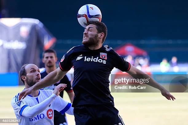 Chris Korb of D.C. United heads the ball in front of Justin Mapp of Montreal Impact during the first half at RFK Stadium on March 7, 2015 in...