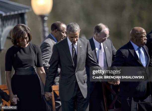 First Lady Michelle Obama, US President Barack Obama, Robert J. Bentley and US Representative John Lewis bow their heads for a prayer at the Edmund...