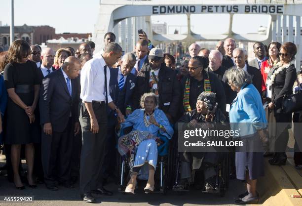 President Barack Obama speaks to Amelia Boynton Robinson , one of the original marchers, alongside First Lady Michelle Obama , and US Representative...