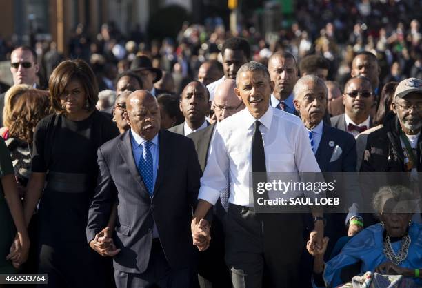 President Barack Obama walks alongside Amelia Boynton Robinson , one of the original marchers, the Reverend Al Sharpton , First Lady Michelle Obama ,...