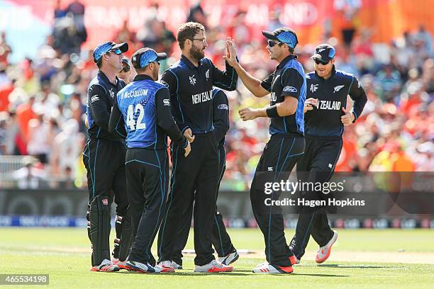 Daniel Vettori of New Zealand is congratulated by teammate Tim Southee after taking the wicket of Usman Ghani of Afghanistan during the 2015 ICC...