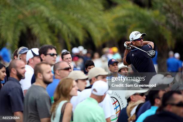 Adam Scott of Australia watches his tee shot on the seventh hole during the third round of the World Golf Championships-Cadillac Championship at...