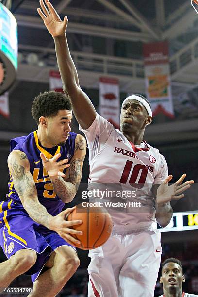 Josh Gray of the LSU Tigers makes a pass out from under the basket while being defended by Bobby Portis of the Arkansas Razorbacks at Bud Walton...