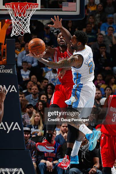 Wilson Chandler of the Denver Nuggets tries to get off a shot against Joey Dorsey of the Houston Rockets at Pepsi Center on March 7, 2015 in Denver,...