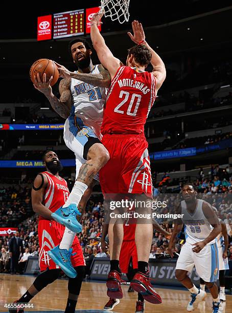 Wilson Chandler of the Denver Nuggets goes up for a shot against Donatas Motiejunas of the Houston Rockets at Pepsi Center on March 7, 2015 in...