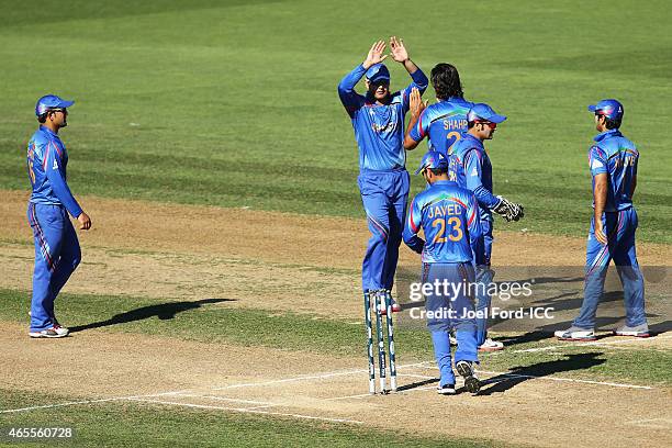 Members of the Afghanistan cricket team congratulate one another after getting a wicket during the 2015 ICC Cricket World Cup match between New...