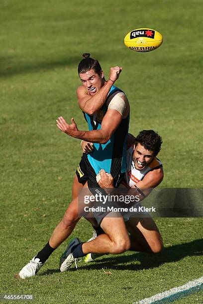 Paul Stewart of the Power passes the ball while getting tackled by Simon Tunbridge of the Eagles during the NAB Challenge match between the Port...