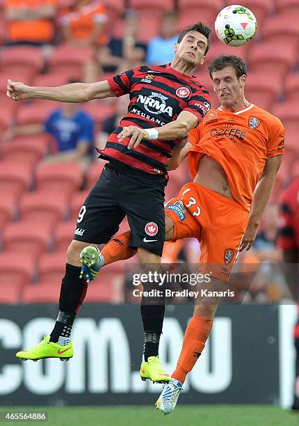 Tom Juric of the Western Sydney Wanderers and Luke DeVere of the Roar challenge for the ball during the round 20 A-League match between the Brisbane...