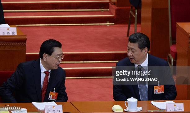 Chinese President Xi Jinping talks to Zhang Dejiang, chairman of the Standing Committee of the National People's Congress , during the third session...