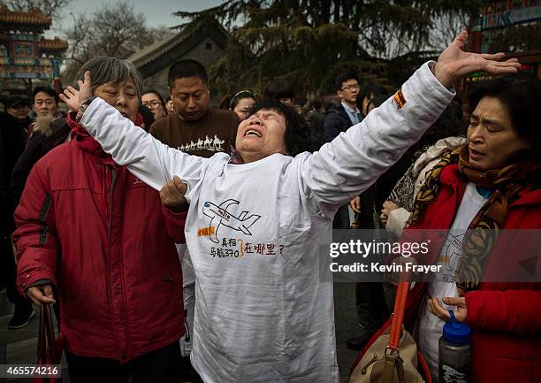 Chinese relative of a missing passenger on Malaysia Airlines flight MH370 reacts as she weeps outside the main gate of the Lama Temple on March 8,...