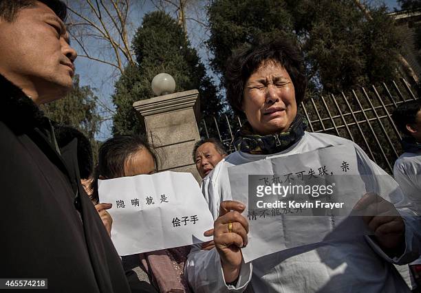 Chinese relative of a missing passenger on Malaysia Airlines flight MH370 cries at a protest outside the Malaysia Embassy on March 8, 2015 in...