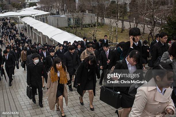 Thousands of students walk to the expo site from the train station to attend the Mynavi Shushoku MEGA EXPO at the Tokyo Big Sight on March 8, 2015 in...