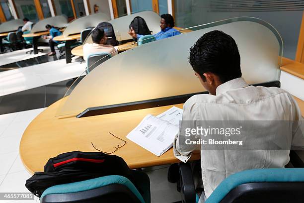 An employee sits working in the library at the Infosys Ltd. Campus in Electronics City in Bangalore, India, on Monday, Jan. 27, 2013. Infosys,...