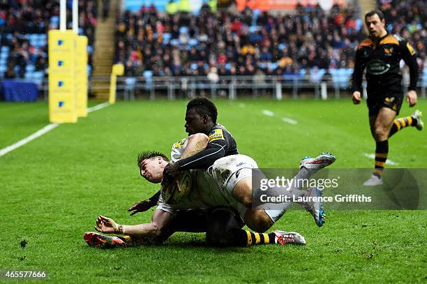 Chris Wyles of Saracens slides over to score his team's try despite thye tackle from Christian Wade of Wasps during the Aviva Premiership match...