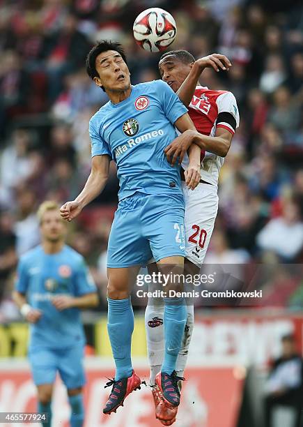 Makoto Hasebe of Frankfurt jumps for a header with Deyverson of Koeln during the Bundesliga match between 1. FC Koeln and Eintracht Frankfurt at...