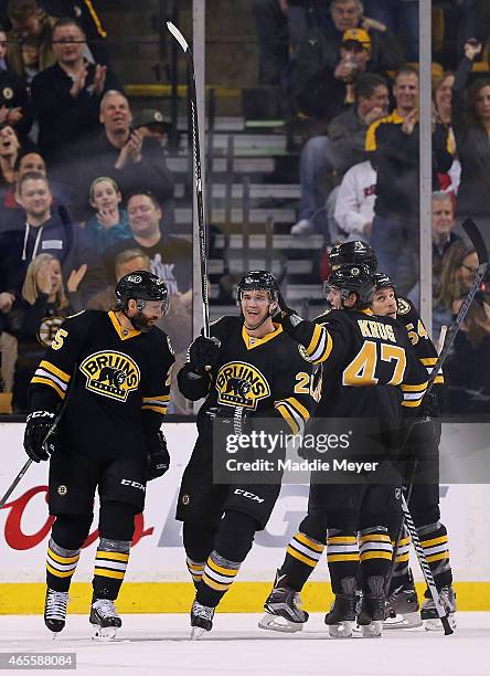 Daniel Paille is congratulated by Maxime Talbot and Torey Krug of the Boston Bruins after he scored a goal against the Detroit Red Wings in the...