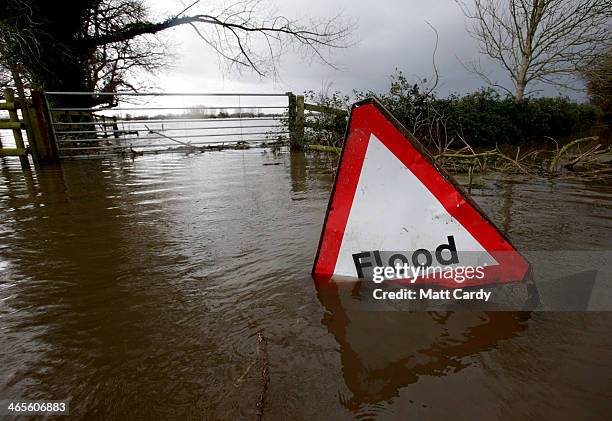 Flood sign is seen in flood waters surrounding farm buildings on January 28, 2014 in Somerset, England. As Lord Smith, the chairman of the...