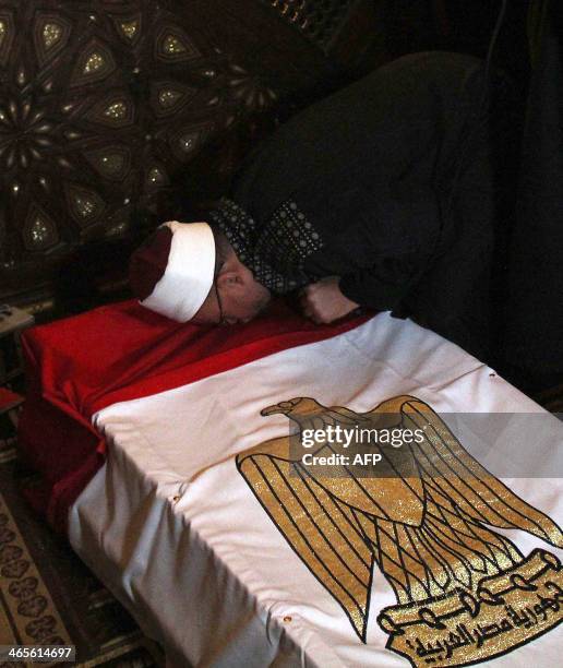 An Egyptian Muslim cleric kisses the coffin of the General Mohamed Saeed during his funeral, on January 28, 2014 in Cairo. Saeed, who was the head of...