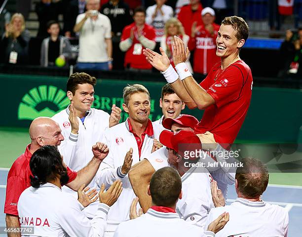 Vasek Pospisil of Canada is carried on the shoulders of his teammates as they celebrate his Davis Cup match win over Go Soeda of Japan March 8, 2015...