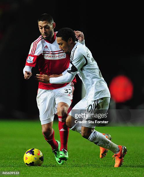 Fulham forward Clint Dempsey is challenged by Jonathan de Guzman of Swansea during the Barclays Premier League match between Swansea City and Fulham...
