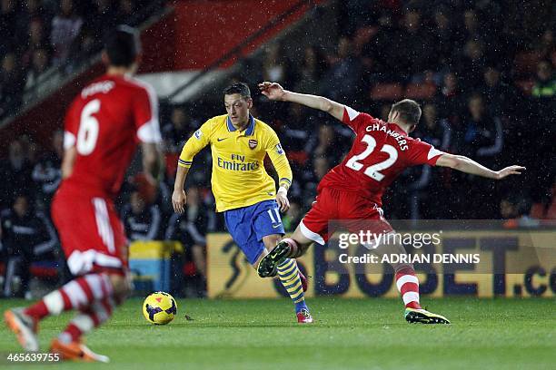 Southampton's English defender Calum Chambers challenges Arsenal's German midfielder Mesut Ozil during the English Premier League football match...