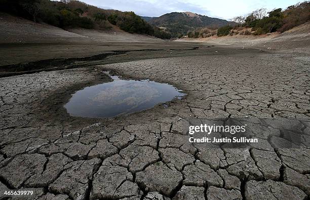 Small pool of water is surrounded by dried and cracked earth that was the bottom of the Almaden Reservoir on January 28, 2014 in San Jose,...