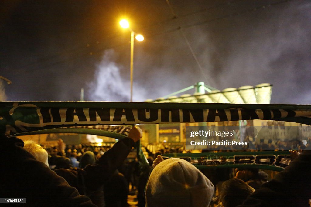 A fan holds up a Panathinaikos scarf. Fans of Greek football...