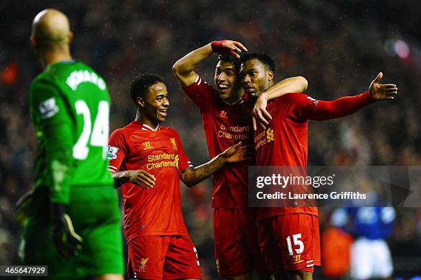 Daniel Sturridge of Liverpool is congratulated by teammates Luis Suarez and Raheem Sterling after scoring his team's third goal as dejected Everton...