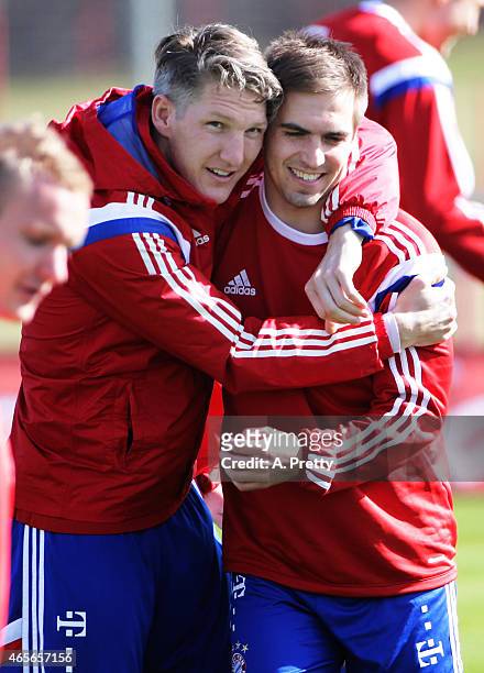 Philipp Lahm is welcomed back to training by Bastian Schweinsteiger of FC Bayern Muenchen during training on March 9, 2015 in Munich, Germany.