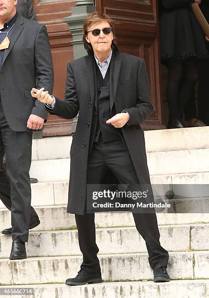 Paul McCartney plays air guitar as he leaves the Stella McCartney show at the Opera Garnier during Paris Fashion Week Fall Winter 2015/2016 on March...