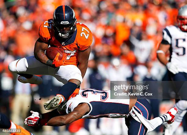 Knowshon Moreno of the Denver Broncos jumps over Duron Harmon of the New England Patriots in the second quarter during the AFC Championship game at...