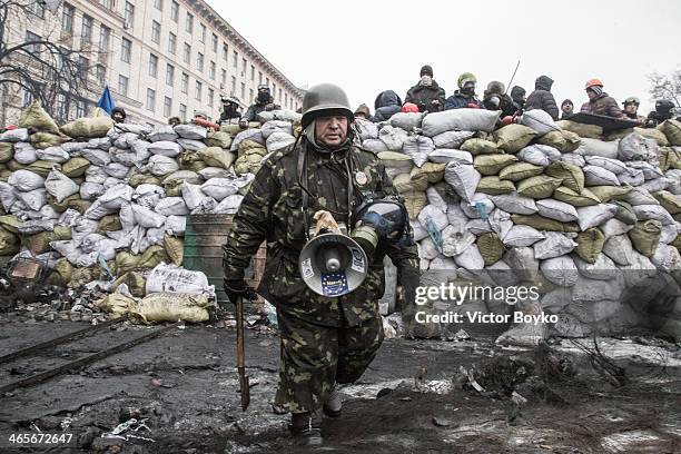 Protester stands guard at the barricade on Grushevskogo Street on January 28, 2014 in Kiev, Ukraine. President Viktor Yanukovych has accepted the...