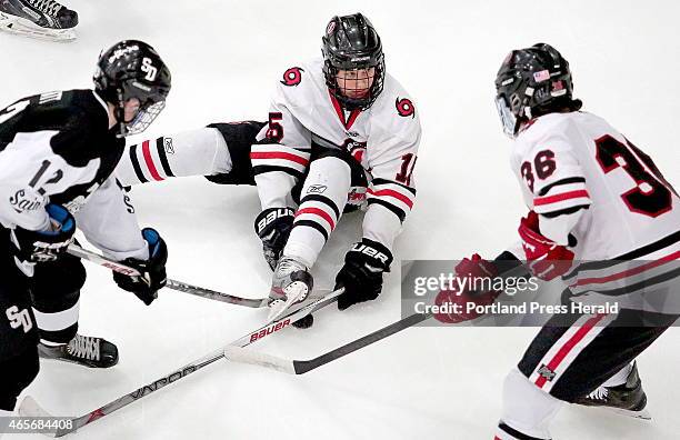 Scarborough's Cameron Smith gets the puck stuck under his skate during first period action as Dillon Pratt of St. Dom's and Scarborough's John...