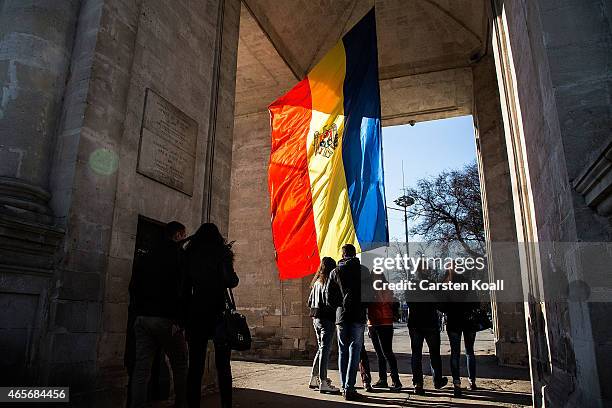 People gather at the Moldovan national flag at the parliament building on March 8, 2015 in Chisinau, Moldova. The Republic of Moldova is a landlocked...