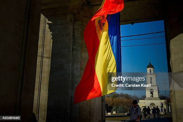 Man passes the Moldovan national flag in front of the cathedral in the Cathedral Park on March 8, 2015 in Chisinau, Moldova. The Republic of Moldova...