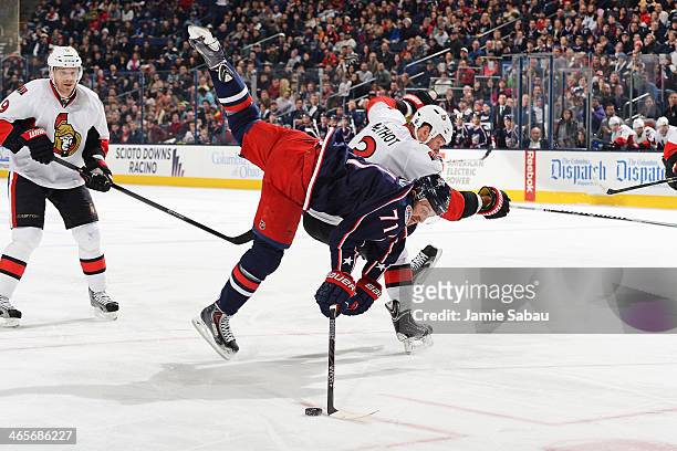 Nick Foligno of the Columbus Blue Jackets continues to play the puck after being hip-checked by Marc Methot of the Ottawa Senators during the third...