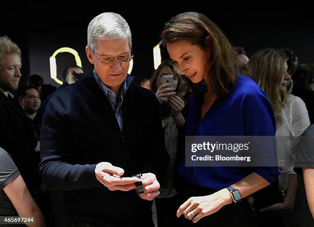 Tim Cook, chief executive officer of Apple Inc., left, views the Apple Watch with model Christy Turlington Burns at the Apple Inc. Spring Forward...